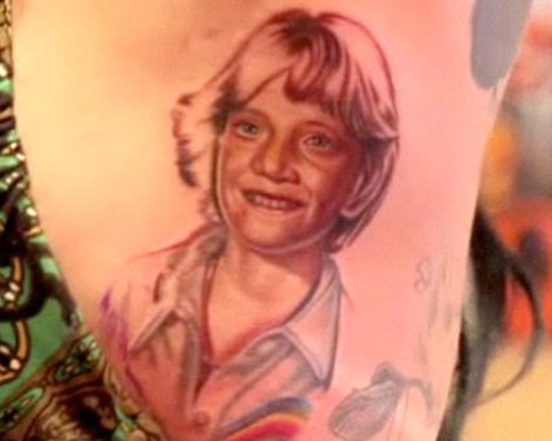 The tattoo is of Jesse from his 5th grade class photograph and she suprised